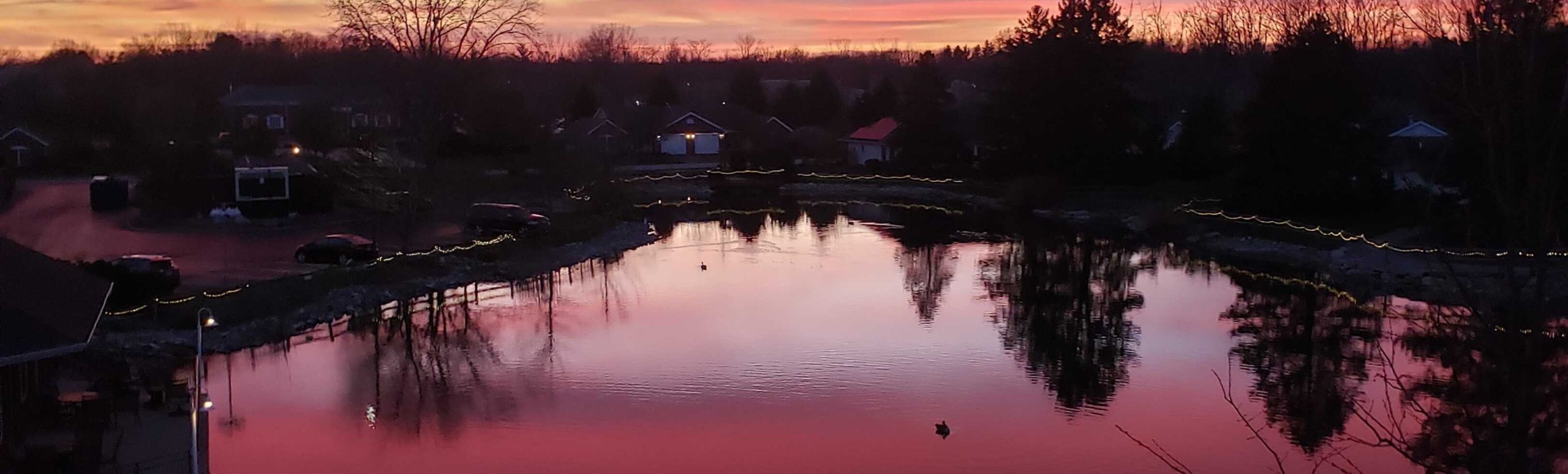 Sunset reflected on the Willow Brook pond in Delaware, Ohio, capturing the peaceful campus atmosphere of this senior living community.