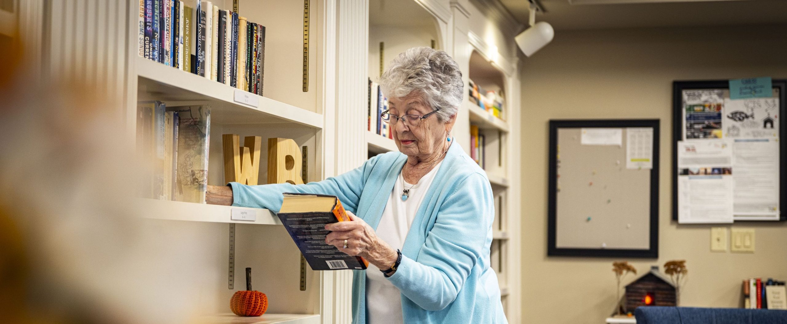A resident enjoys quiet reading at Willow Brook in Delaware, Ohio, used as a full-width background image on the Companion Services page.