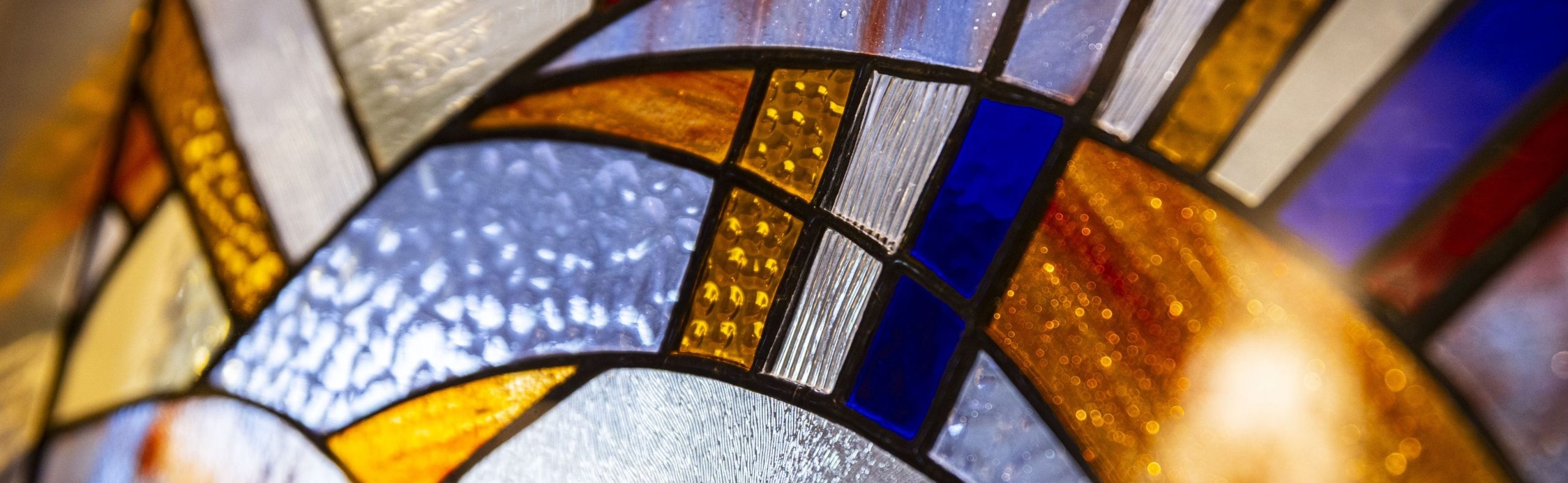 Stained glass detail used as the desktop header for the Willow Brook blog page in Delaware, Ohio, reflecting the faith-centered identity of this senior living community.