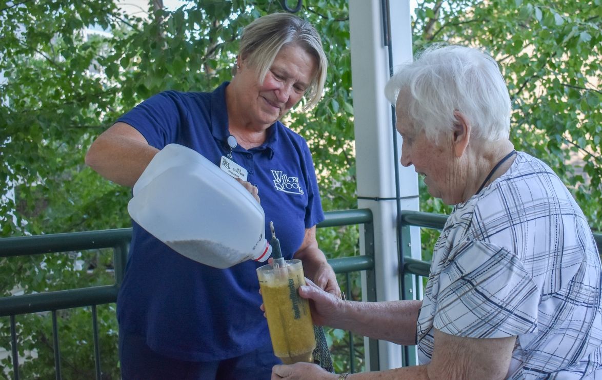 A Willow Brook companion staff member helps a resident on the porch in Delaware, Ohio, featured in the home page community resources section for companion services.