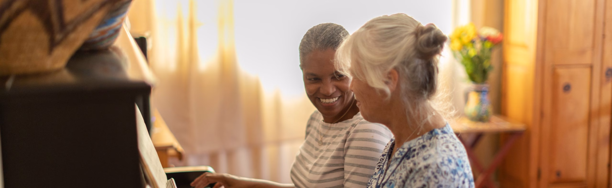 Wide desktop banner showing a memory care moment at the piano at Willow Brook in Delaware, Ohio, where music and meaningful engagement support residents with dementia and Alzheimer's.