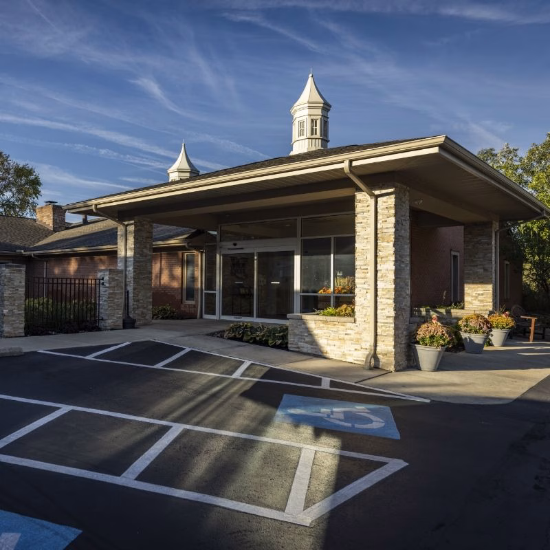 The covered entrance at Willow Brook Home in Columbus, Ohio, featuring a stone facade and cupola — the welcoming front of this five-star assisted living and rehabilitation community.