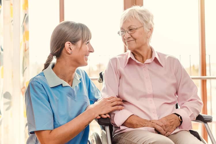 A caregiver placing their hand over their loved one’s arm.